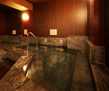 Stone and wooden indoor onsen bath with warm lighting at Arima Royal Hotel, Hyōgo, Kansai