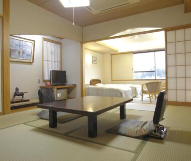 Tatami room with low table, chairs, beds and shoji screens at Arimakan in Yamagata, Tōhoku, Japan