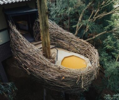 Circular wooden soaking tub in nest-like balcony among forest trees at Arimasansoh Goshobessho, Hyōgo
