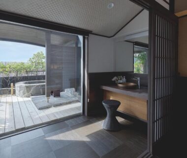 Sliding doors to wooden deck with outdoor bath, interior vanity, tiled floor and shoji screens at Arujisu, Shizuoka