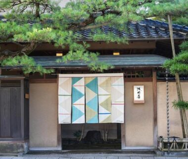 Noren curtain at Asadaya entrance with wooden facade and pine trees, Ishikawa, Chūbu