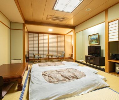 Traditional tatami room with futon bedding, shoji screens and low table at Asagiriso, Hyōgo, Kansai