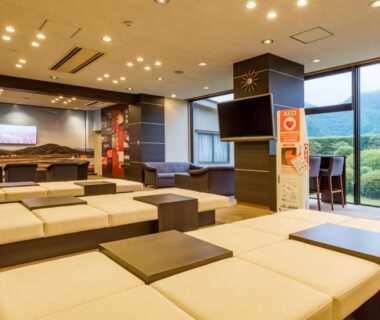 Low cushioned seating and tables with large windows overlooking greenery at Asagiriso Hyōgo