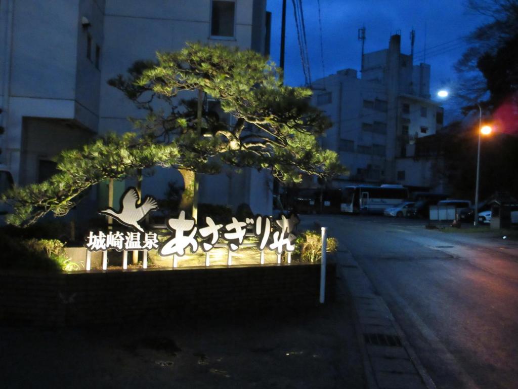 Entrance sign at dusk Asagiriso Hyōgo Illuminated Asagiriso entrance sign at dusk beside street and urban buildings in Hyōgo