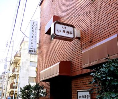 Red brick facade with Asakusa Ryokan Toukaisou signage on a narrow Tokyo street