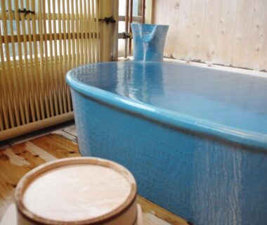 Blue ceramic soaking tub with wooden bucket in ryokan bathing area at Asanoya, Hyōgo, Kansai