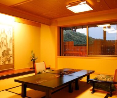 Japanese tatami room with low table, floor chairs, hanging scroll and window view at Asanoya in Hyōgo, Kansai