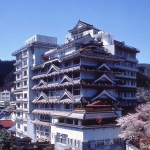 Multi-storey ryokan with traditional gabled roofs and cherry blossoms visible in Hyōgo, Kansai