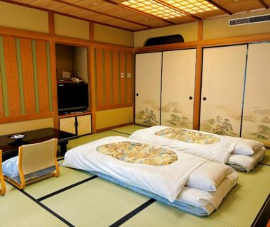 Tatami room with futon bedding, shoji screens and low table at Asanoya in Hyōgo, Kansai