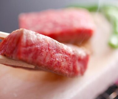 Marbled beef slice held by chopsticks at Asanoya ryokan in Hyōgo, Kansai