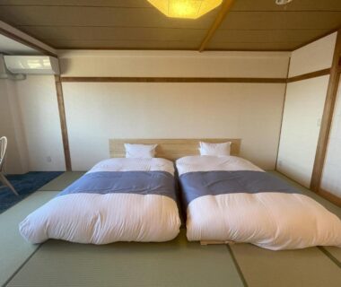 Twin futon bedding on tatami floor in a simple Japanese-style room at Ashiwada Hotel, Yamanashi