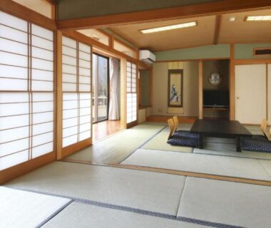 Spacious tatami room with low table, shoji screens and mountain view at Ashiwada Hotel, Yamanashi