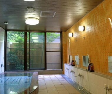 Communal tiled bathing room with showers and soaking tub at Asia Hotel FUJISAN in Yamanashi, Chūbu