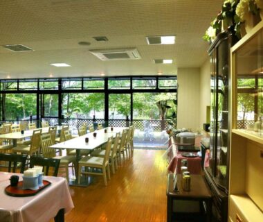 Spacious dining area with wooden tables and garden view at Asia Hotel FUJISAN in Yamanashi