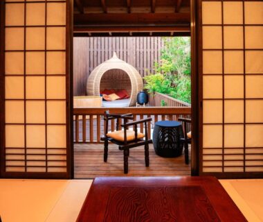 Tatami room with shoji doors opening to wooden veranda, woven lounge chair and garden at AsoTsuruya Kumamoto Kyushu
