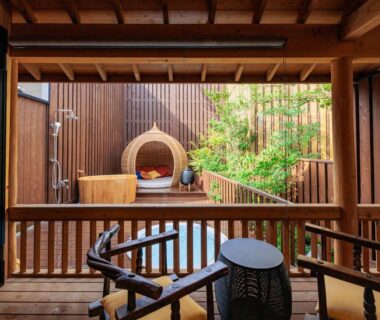 Wooden soaking tub and wicker lounge chair on balcony at AsoTsuruya, Kumamoto, Kyūshū, Japan
