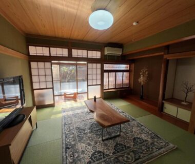 Traditional tatami room with low wooden table, shoji screens, wooden ceiling and decorative alcove