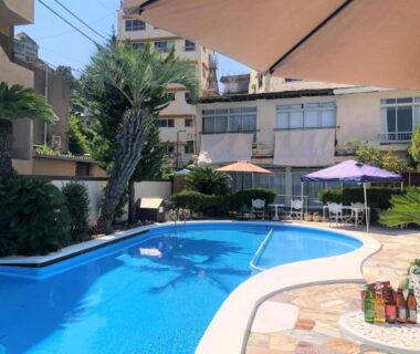 Outdoor swimming pool with patio umbrellas and lounge seating at Atagawa Yamatokan in Shizuoka