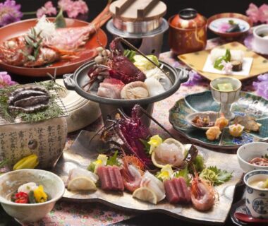 Assortment of traditional Japanese small dishes, sliced seafood, hot pot and decorative garnishes