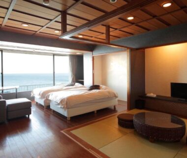 Mixed-style room with Western beds, tatami seating and ocean view at Atagawa Yamatokan, Shizuoka