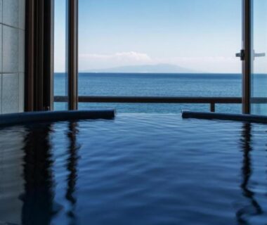 Indoor onsen bath facing calm sea horizon through open wall at Atagawakan, Shizuoka, Chūbu