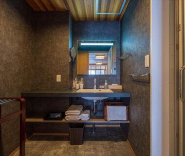 Sink and mirror with folded towels in ryokan bathroom at Atami Onsen Yamaki, Shizuoka, Chūbu Japan