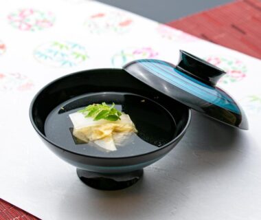 Lacquer bowl of clear broth with tofu cube and green garnish at Atami Onsen Yamaki Ryokan, Shizuoka