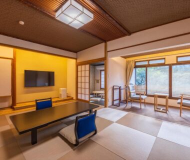 Spacious tatami room with low table, seating near window at Atami Onsen Yamaki Ryokan, Shizuoka