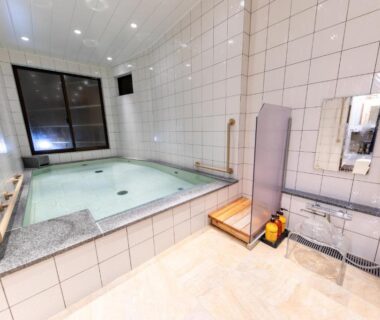 Tiled indoor bath with shower station, wooden stool and handrails, Atami Onsen Yamaki Ryokan, Shizuoka