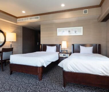 Twin beds and desk in modern guest room at Atami Season Hotel, Shizuoka