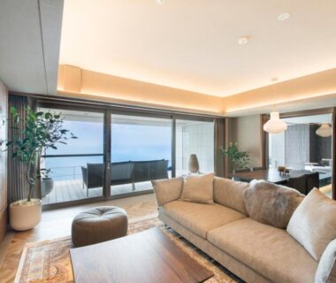 Spacious lounge with sofa and balcony overlooking the sea at Atami Sekaie, Shizuoka Chūbu