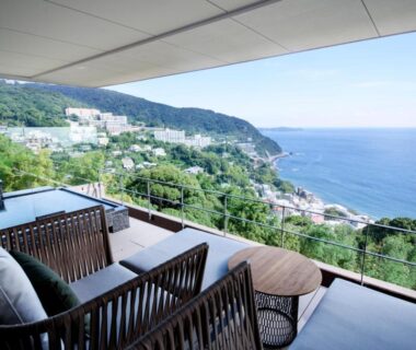 Balcony seating overlooking coastline at Atami Sekaie in Shizuoka, Chūbu, Japan