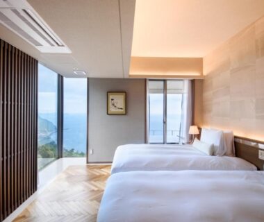 Twin beds and floor-to-ceiling windows with coastal view at Atami Sekaie, Shizuoka, Chūbu, Japan