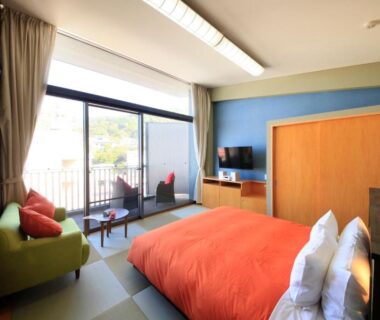 Low bed on tatami with balcony and sofa at Atami Tensui Shizuoka