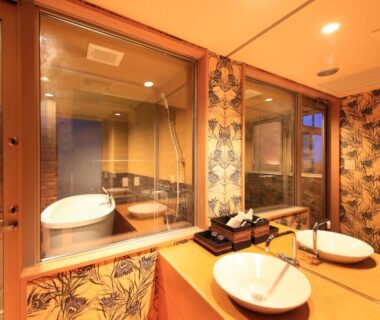 Double sink vanity and glass-partitioned room with wooden soaking tub at Atami Tensui in Shizuoka