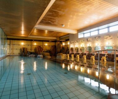 Large indoor tiled onsen with wash stations and stools at Awazuonsen Kitahachi, Ishikawa, Chūbu