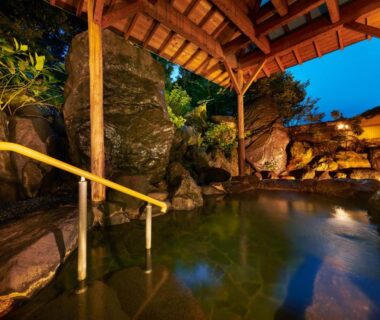 Covered outdoor onsen with rock bath and wooden roof at Awazuonsen Kitahachi, Ishikawa, Chūbu