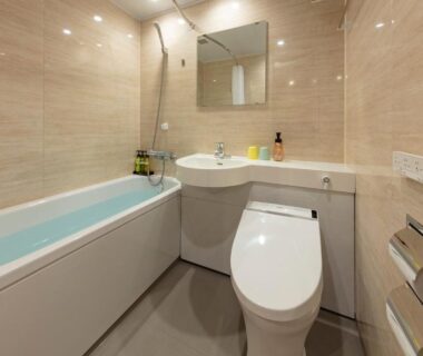 Compact tiled bathroom with bathtub sink and toilet at Azumakan Fukushima Tohoku