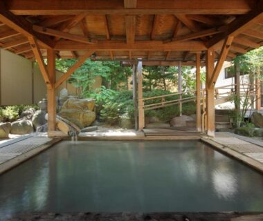 Covered stone onsen bath with wooden beams at Azumakan Fukushima Tōhoku