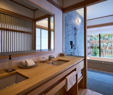 Wooden double sink vanity with soaking tub by window and bamboo garden view at Azumi Setoda, Hiroshima