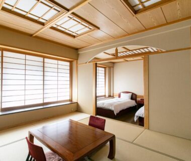 Tatami seating area with adjoining Western beds at Baien ryokan in Oita, Kyūshū