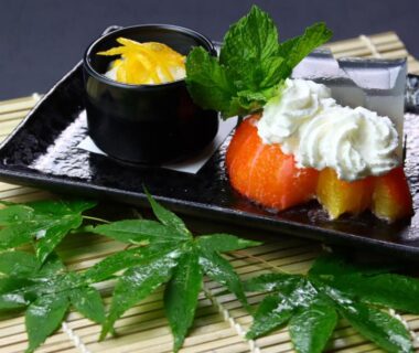 Assorted Japanese desserts with fruit, whipped cream and jelly on black tray at Baigetsu Ryokan, Nagano