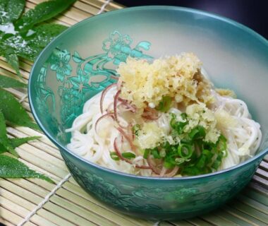 Glass bowl of chilled somen noodles with green onions and tempura flakes at Baigetsu Ryokan Nagano