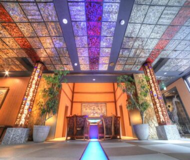 Luminous lobby with stained glass panels and potted plants at Balinese onsen ryokan Hakone Airu, Kanagawa, Japan