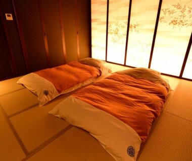 Traditional tatami room with two futons and illuminated shoji screens at Hakone Airu in Kanagawa