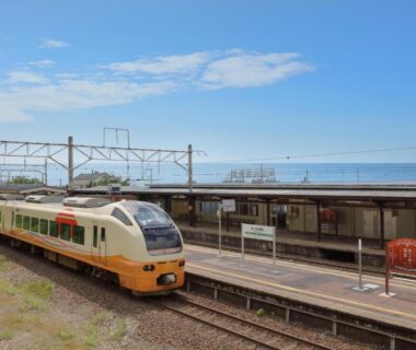 Coastal train stopped at platform with sea view, approach route to Bankokuya in Yamagata