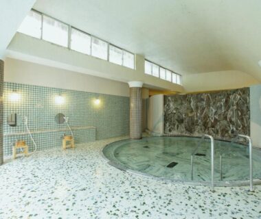Indoor tiled communal onsen with washing stations and round bath pool at Bansuirou Fukuzumi Kanagawa