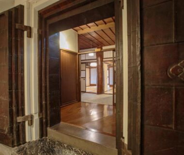 Heavy metal entrance doors leading to polished wooden foyer and shoji screens at Bansuirou Fukuzumi, Kanagawa