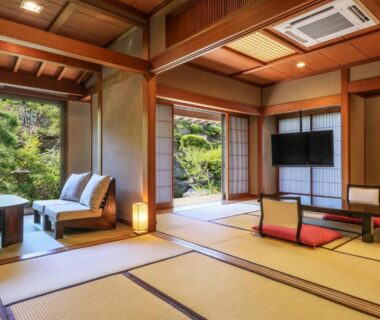 Tatami room with low table and seating, sliding doors to garden at Kagetsu, Yamanashi