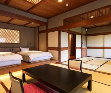 Spacious tatami room with low table and beds at Beautiful Japanese Garden Kagetsu in Yamanashi